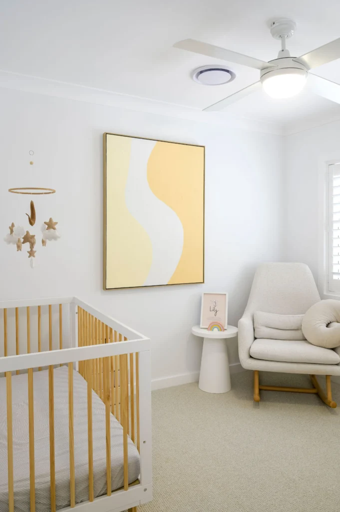 Cozy nursery or child's bedroom with yellow artwork and cane chair