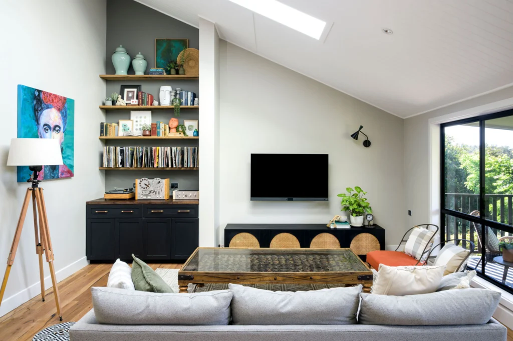 Modern living room with built-in shelving, TV, and white sofa