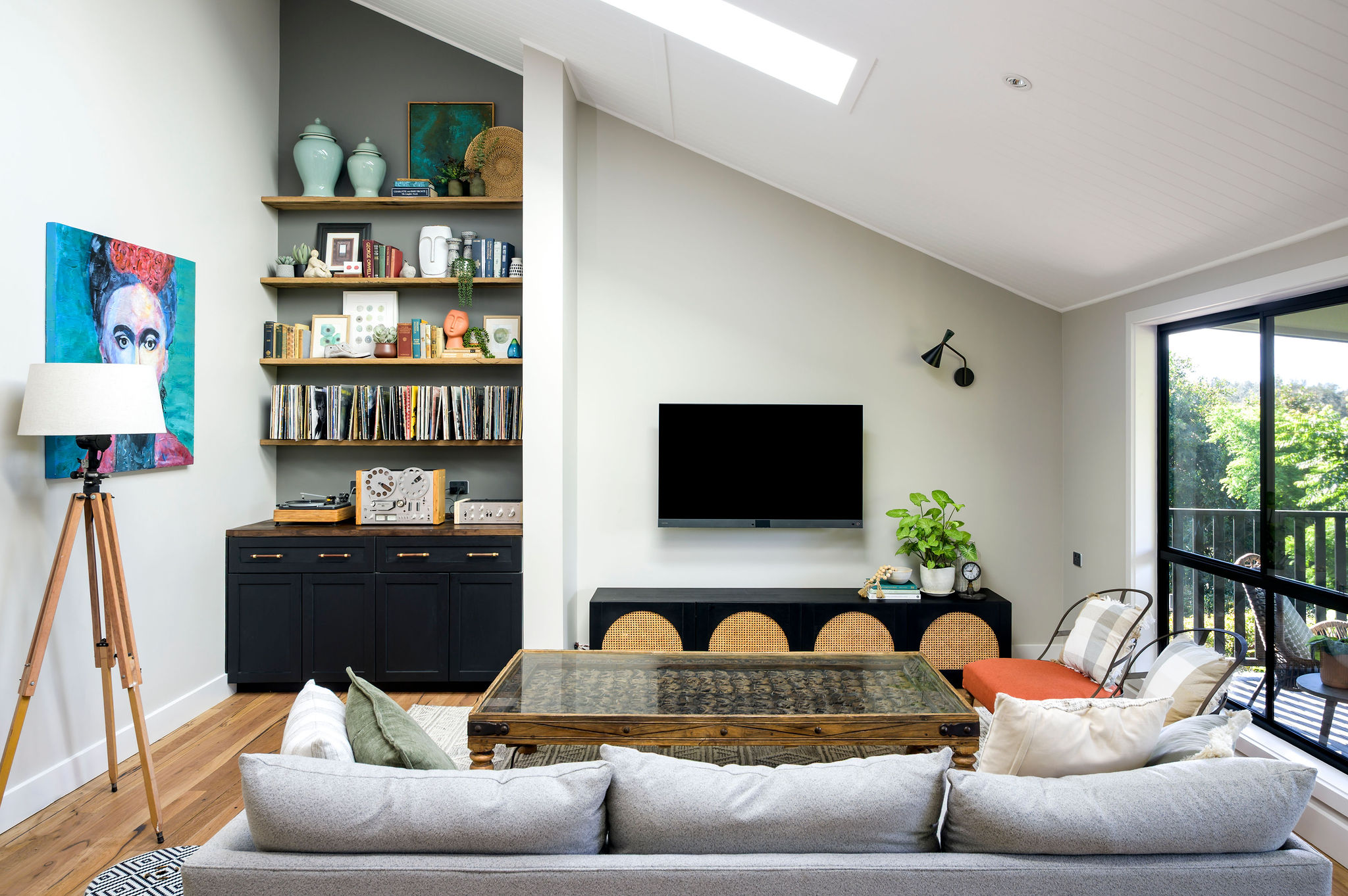 Modern living room with built-in shelving, TV, and white sofa